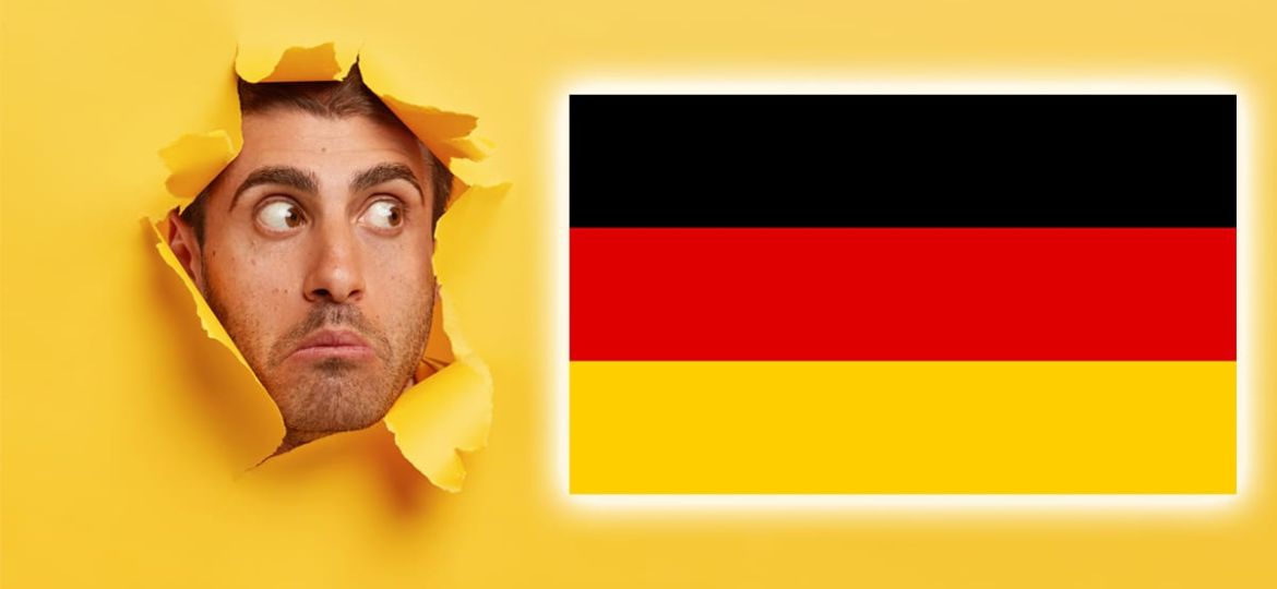 Face of surprised scared young man gazes through yellow paper hole aside, sees something shocking, has wide opened eyes, bristle, isolated over yellow background, free space for your promotion