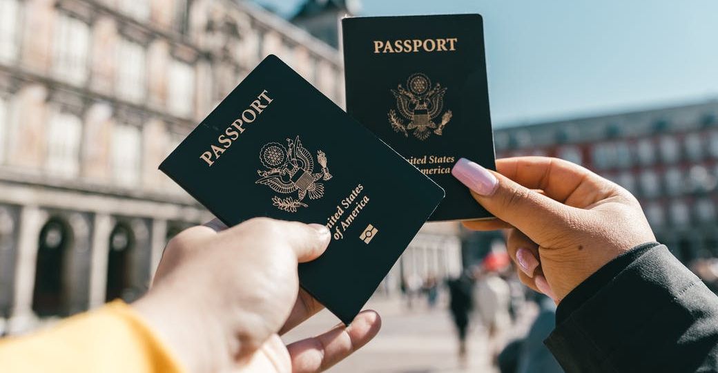 anonymous tourists showing us passports on street on sunny day